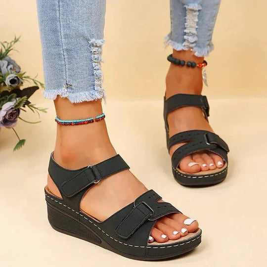 Black adjustable twin-strap wedge sandals with open toe and thick textured sole