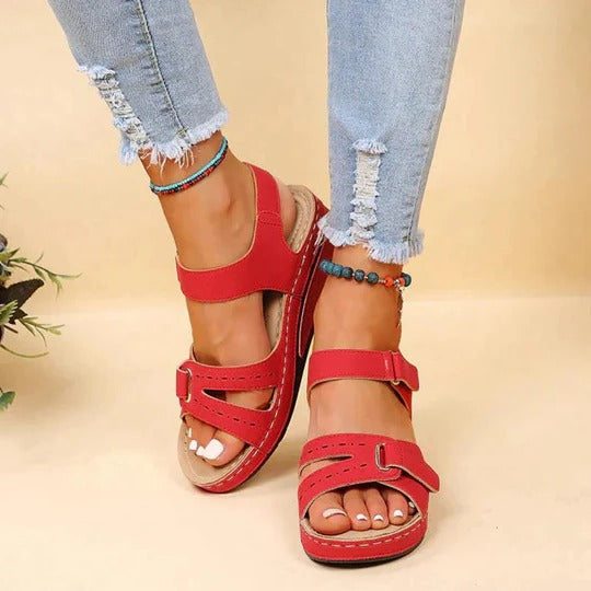 Red suede-texture wedge sandals with cutout details and adjustable buckle straps