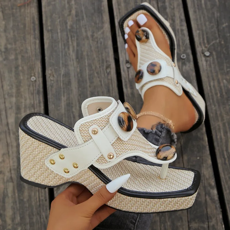 Close-up of beige woven slide sandal with tortoiseshell button detail