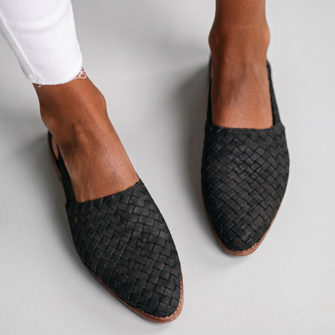 Black woven orthopedic sandals with dense basket-weave texture and slip-on style