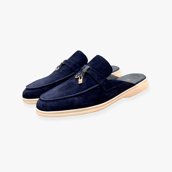 Navy blue slip-on suede loafers featuring gold lock hardware and beige flat sole