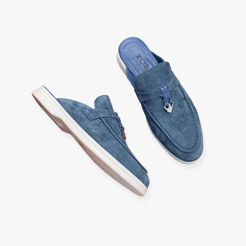 Blue backless suede mule loafers with metal anchor accent and cushioned white sole