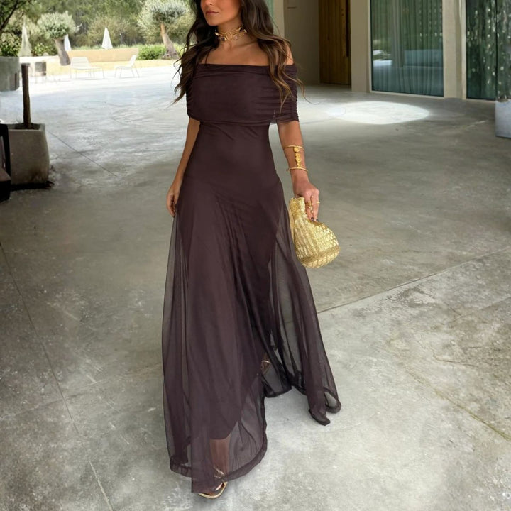 Woman walking in dark brown off-shoulder maxi dress with flowing sheer skirt