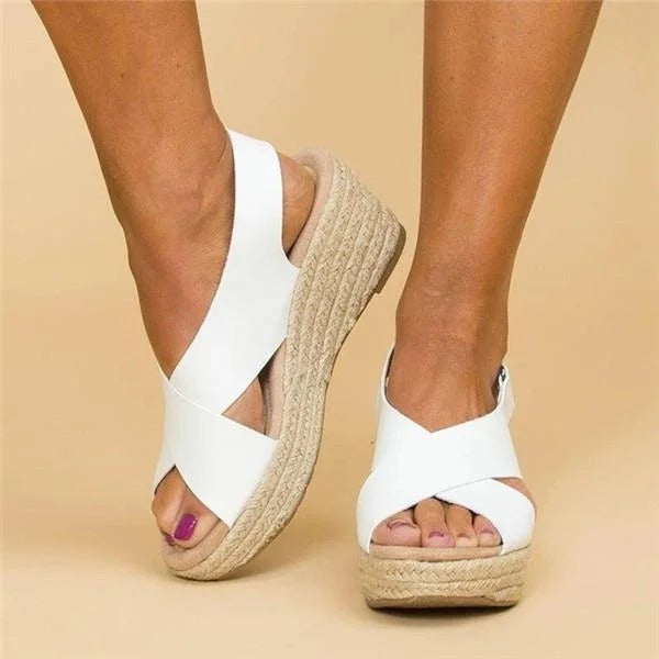 Side view of white orthopedic wedge sandals showing criss-cross straps and cushioned sole