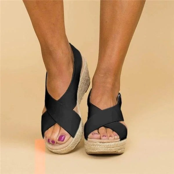 Front view of black cross strap wedge sandals highlighting open toe design and arch support