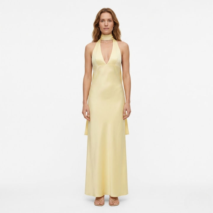 Woman modeling yellow halter neck maxi dress with deep V-plunge front