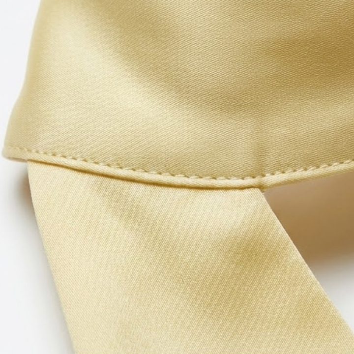 Detail shot of pale yellow satin weave and precise hem stitching