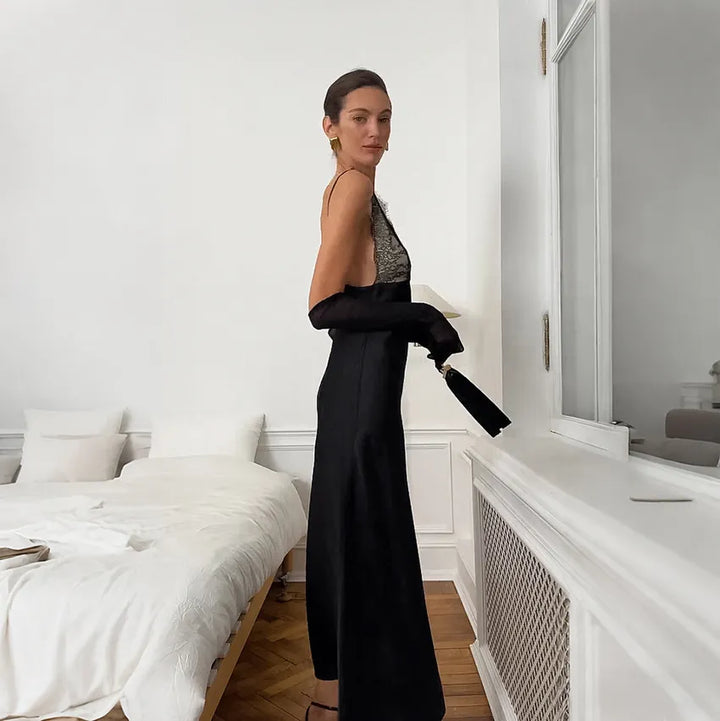 Floor-length champagne satin slip dress with black lace trim and open back