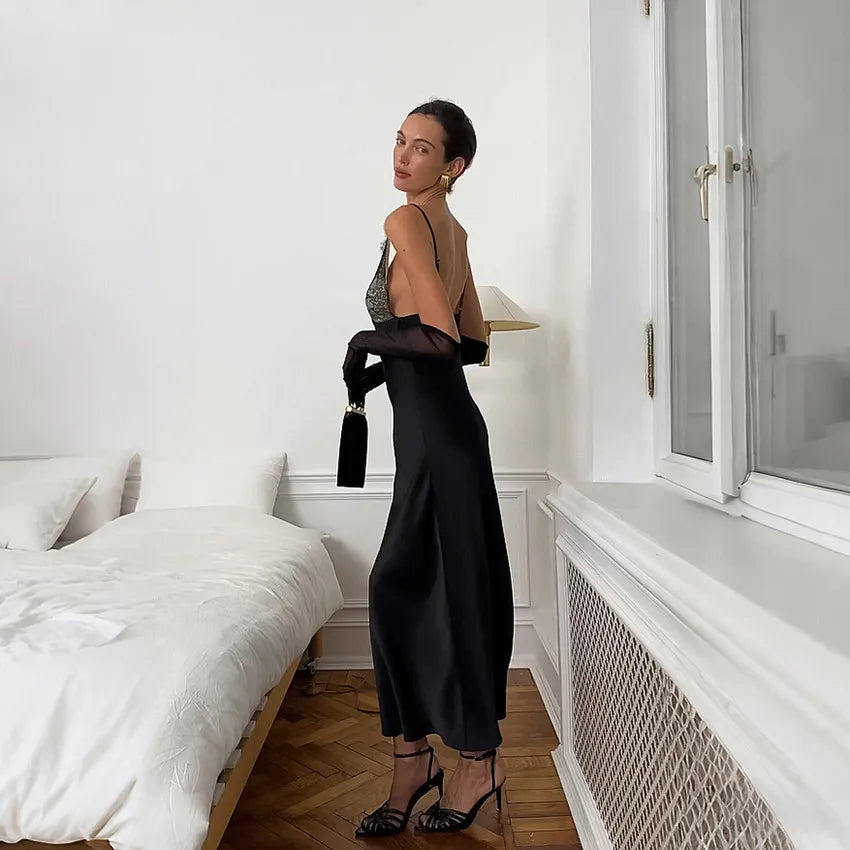 Woman wearing contrast black lace bodice champagne satin midi dress at night