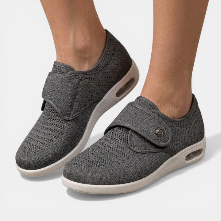 Gray perforated knit orthopedic sneaker with adjustable instep strap and white air sole