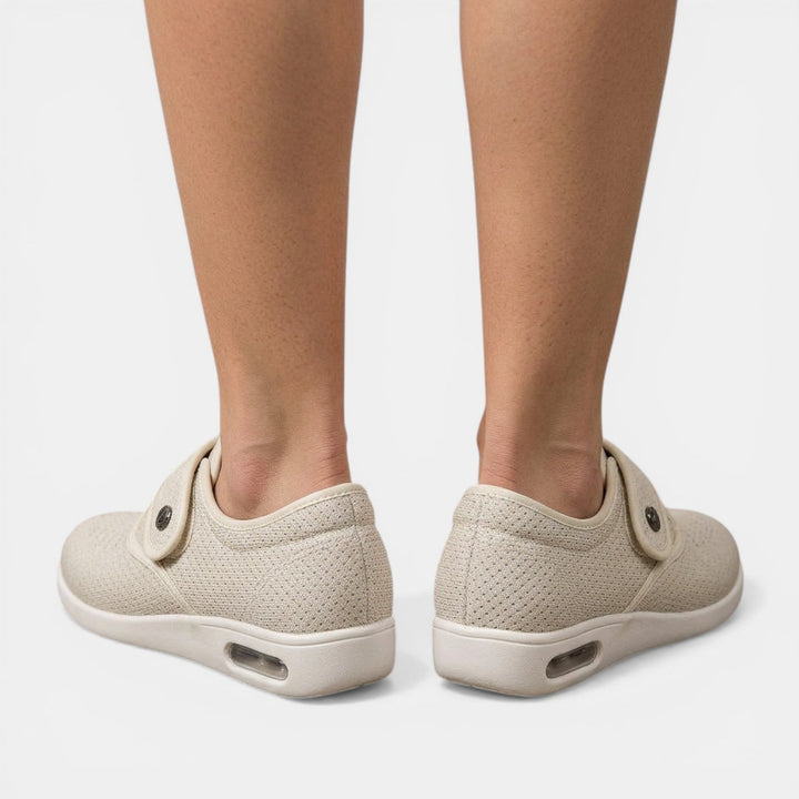 Rear view of beige orthopedic walking shoes showing curved velcro strap and air cushion sole