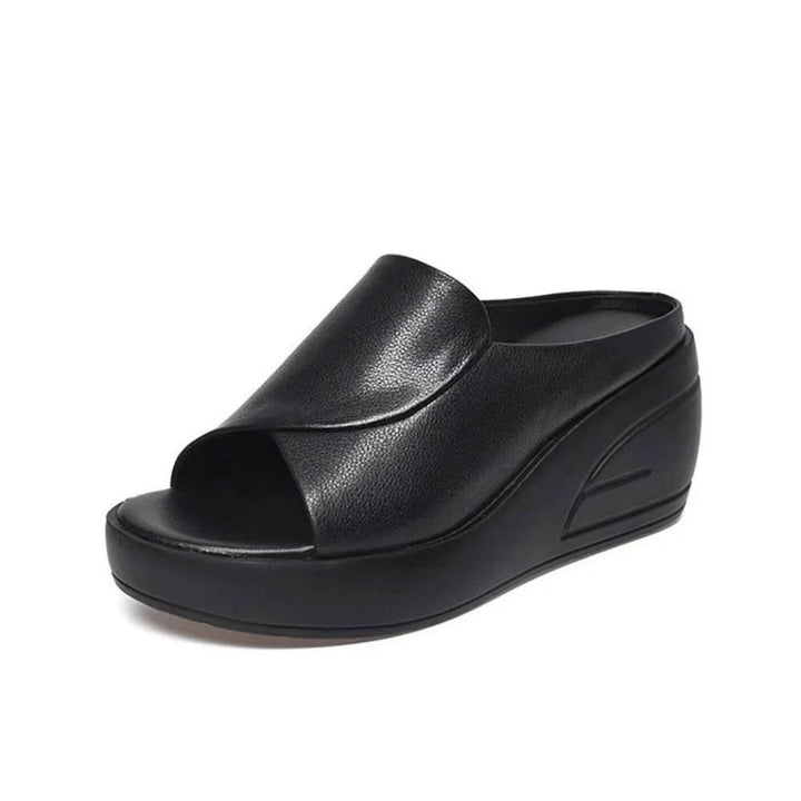 Black faux leather peep toe wedge sandal showing embossed geometric side detail