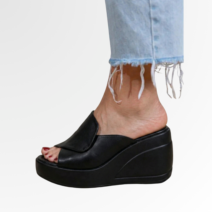 Black orthopedic wedge sandal with thick platform sole and backless slip-on design