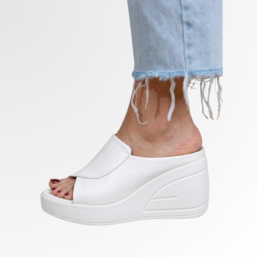 White peep toe platform wedge sandal with faux leather upper and curved cutout sole detail