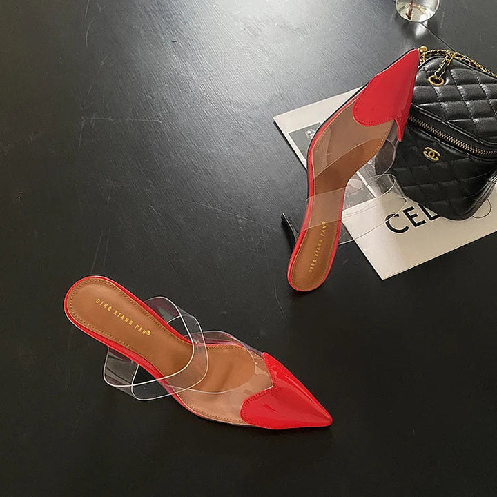 Red patent heart-toe stiletto mules with clear PVC strap showing side profile heel
