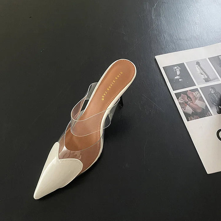White patent heart-toe stiletto mule with clear PVC strap and gold embossed insole