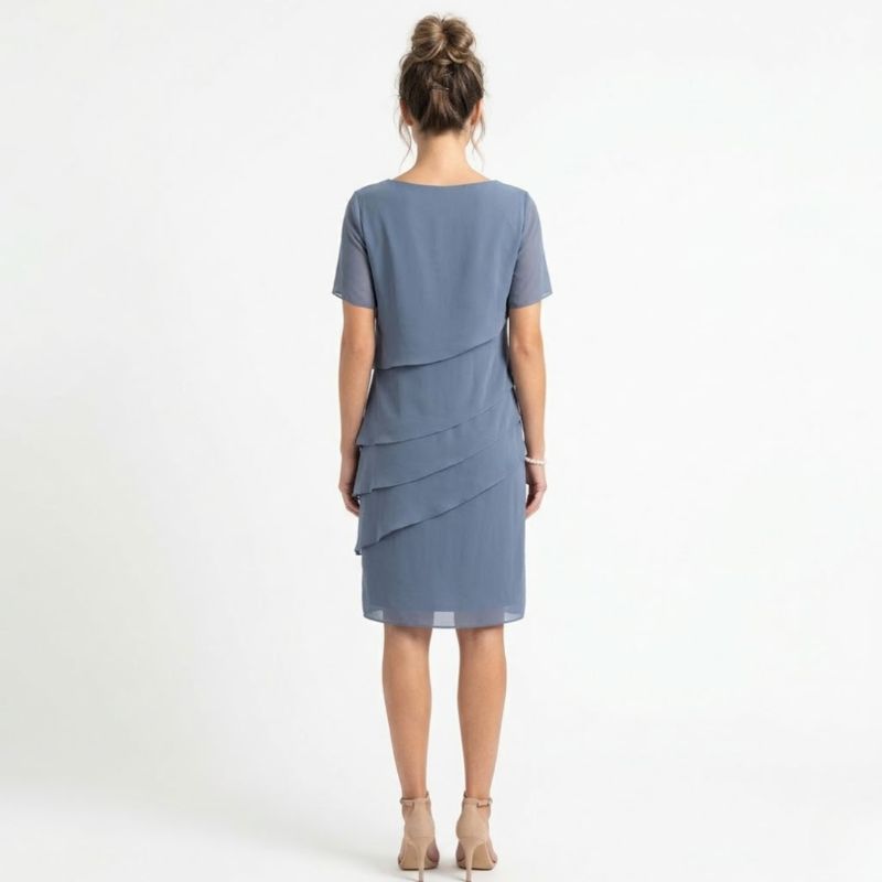 Back view of blue tiered chiffon dress featuring asymmetrical ruffled side drape