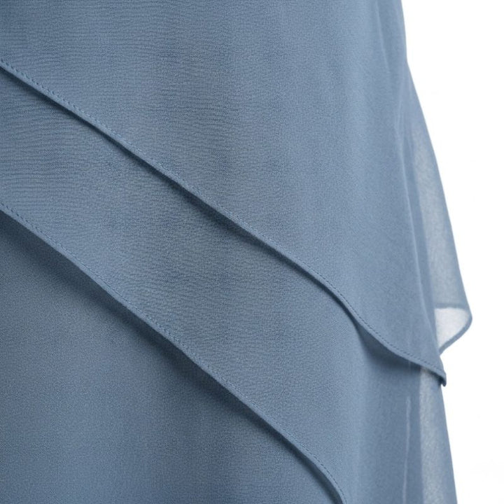 Close-up of dusty blue chiffon fabric showing three-tiered diagonal ruffle layers