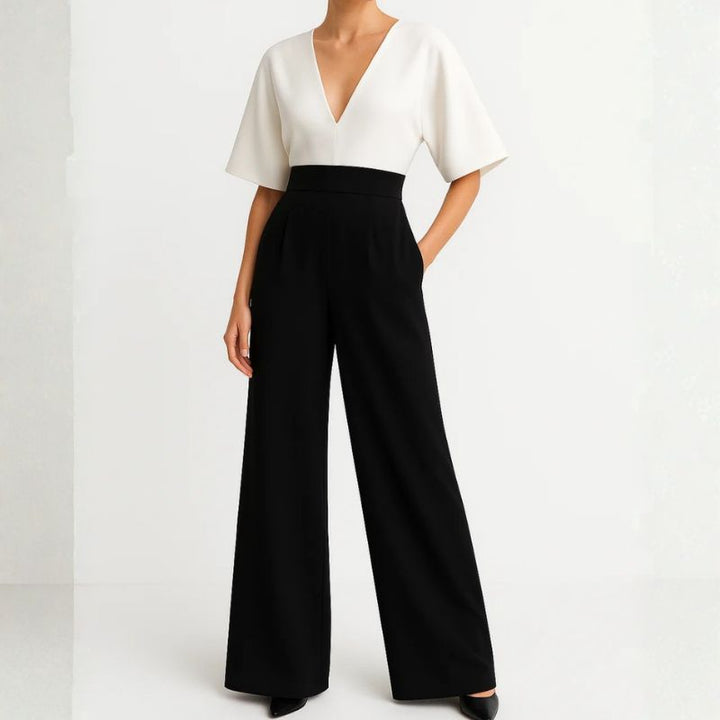 Women's white and black two-piece jumpsuit with deep V-neck, draped sleeves, and high-waisted wide-leg trousers