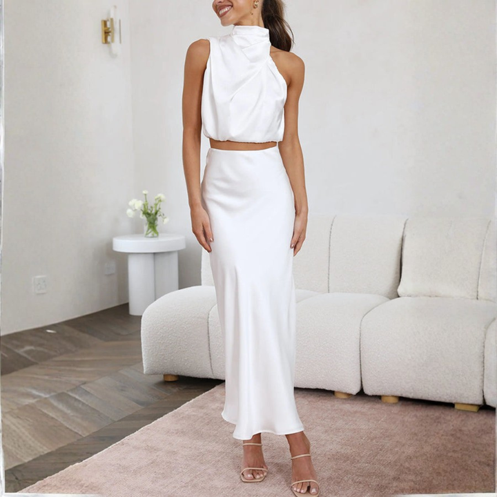 white satin halter neck crop top and floor length maxi skirt ensemble